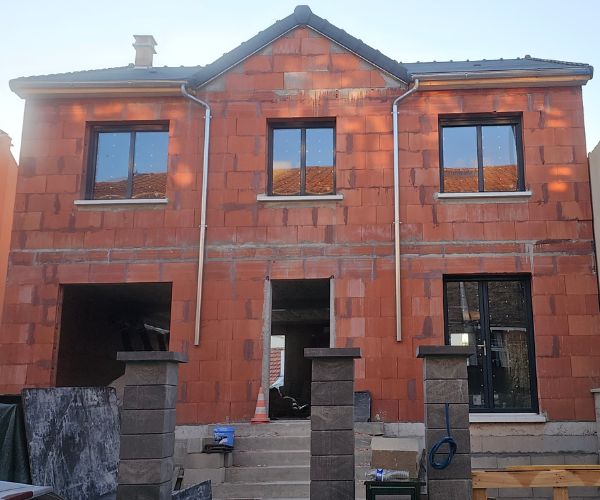 Façade en briques rouges d’une maison en construction